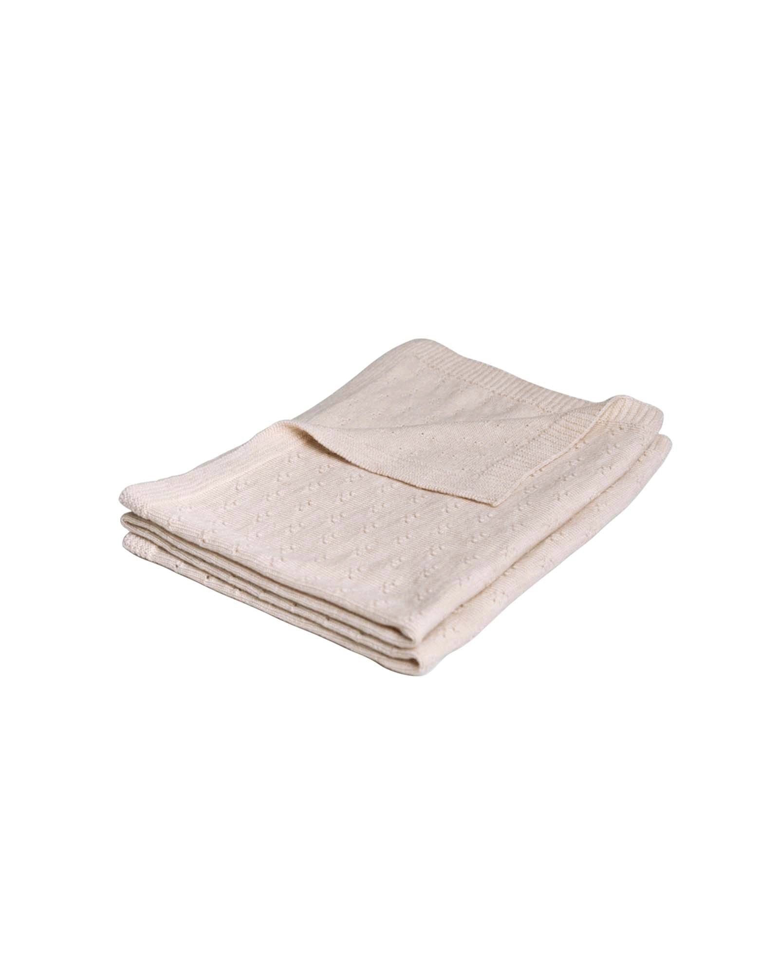 Folded cream merino wool baby blanket with a subtle knit pattern.