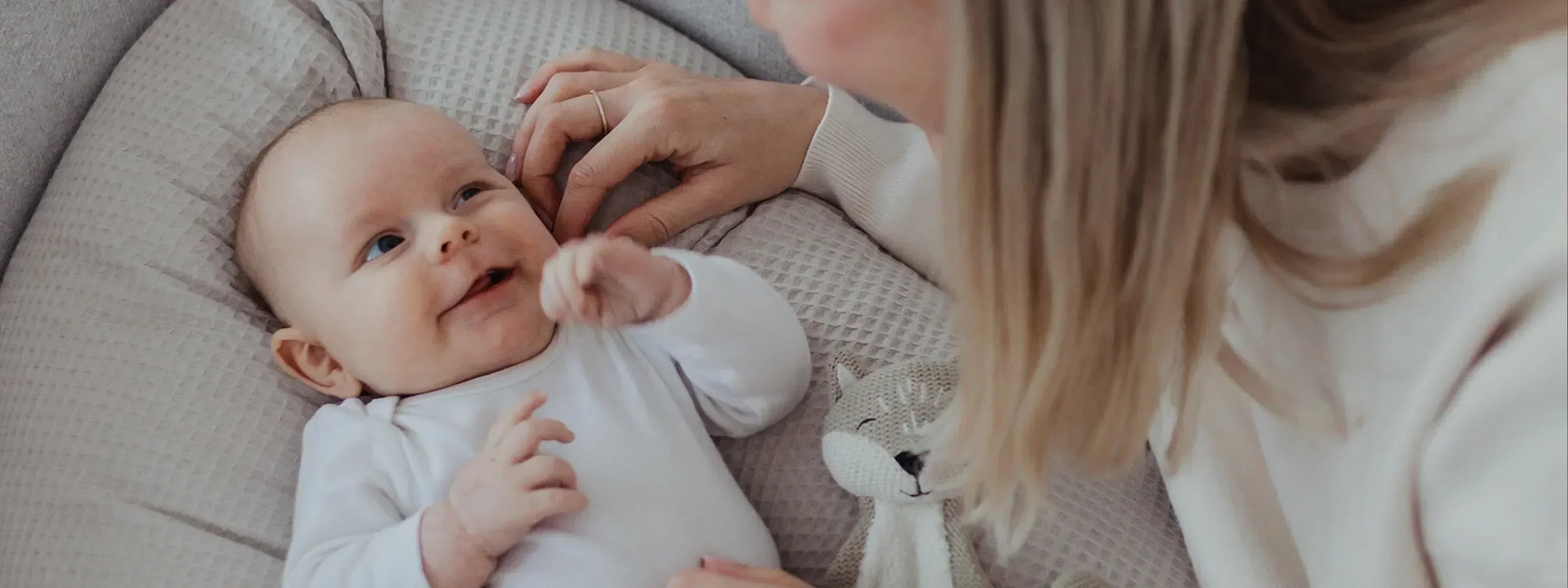ULLENBOOM® Blogartikel beliebte Babynamen 2025 - Baby auf Stillkissen Waffelpiqué Sand
