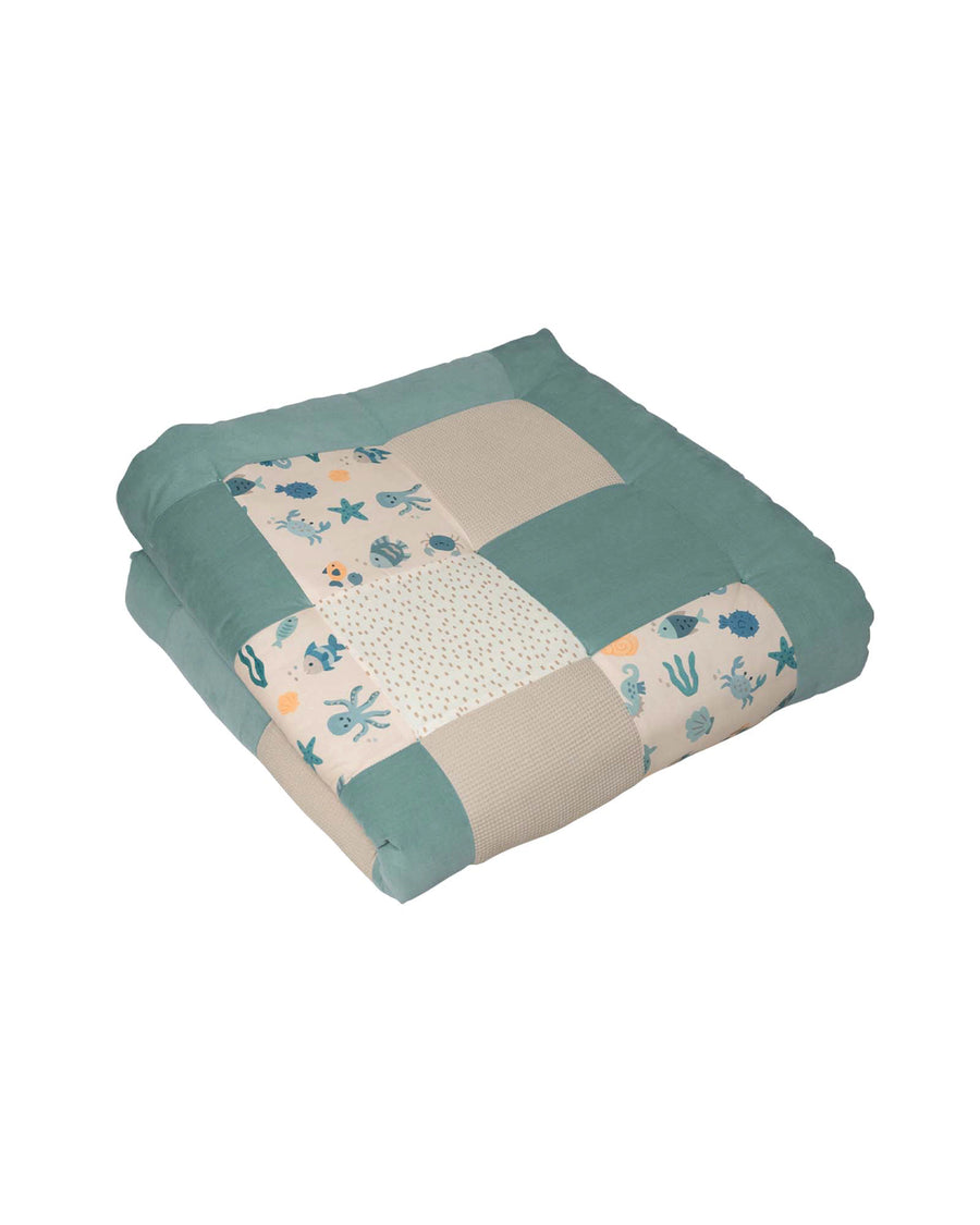 Patchwork baby play mat with underwater sea creatures, in soft teal and beige cotton.