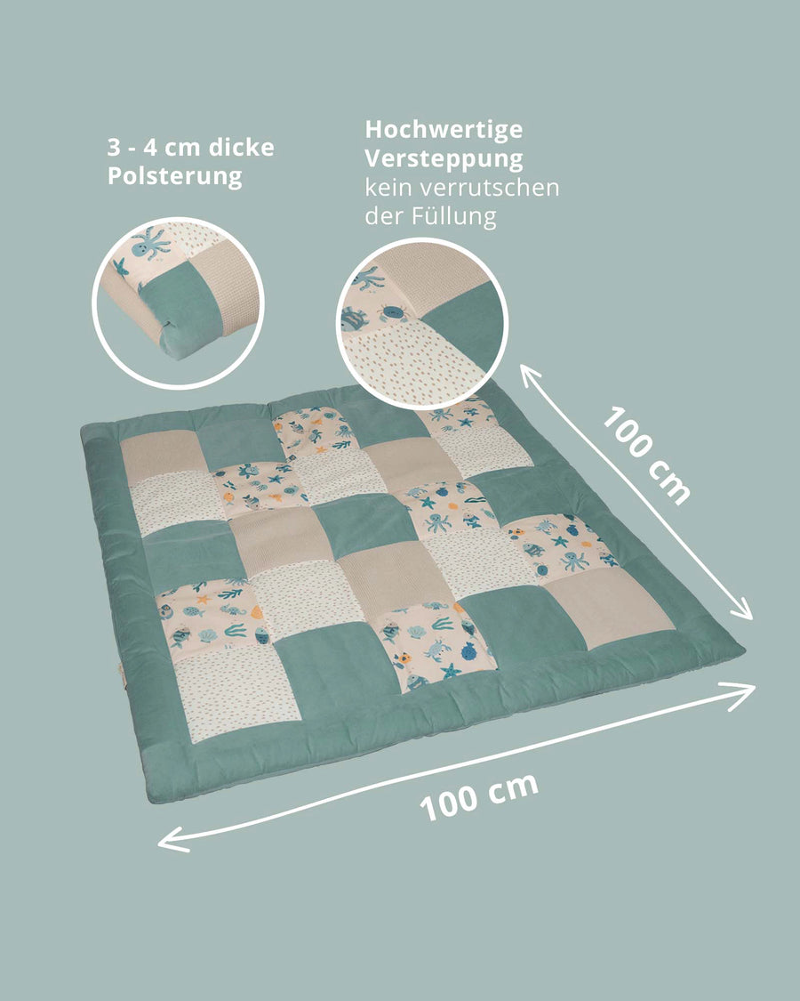Square, thick quilted playmat with teal and beige patchwork, featuring an underwater world design.