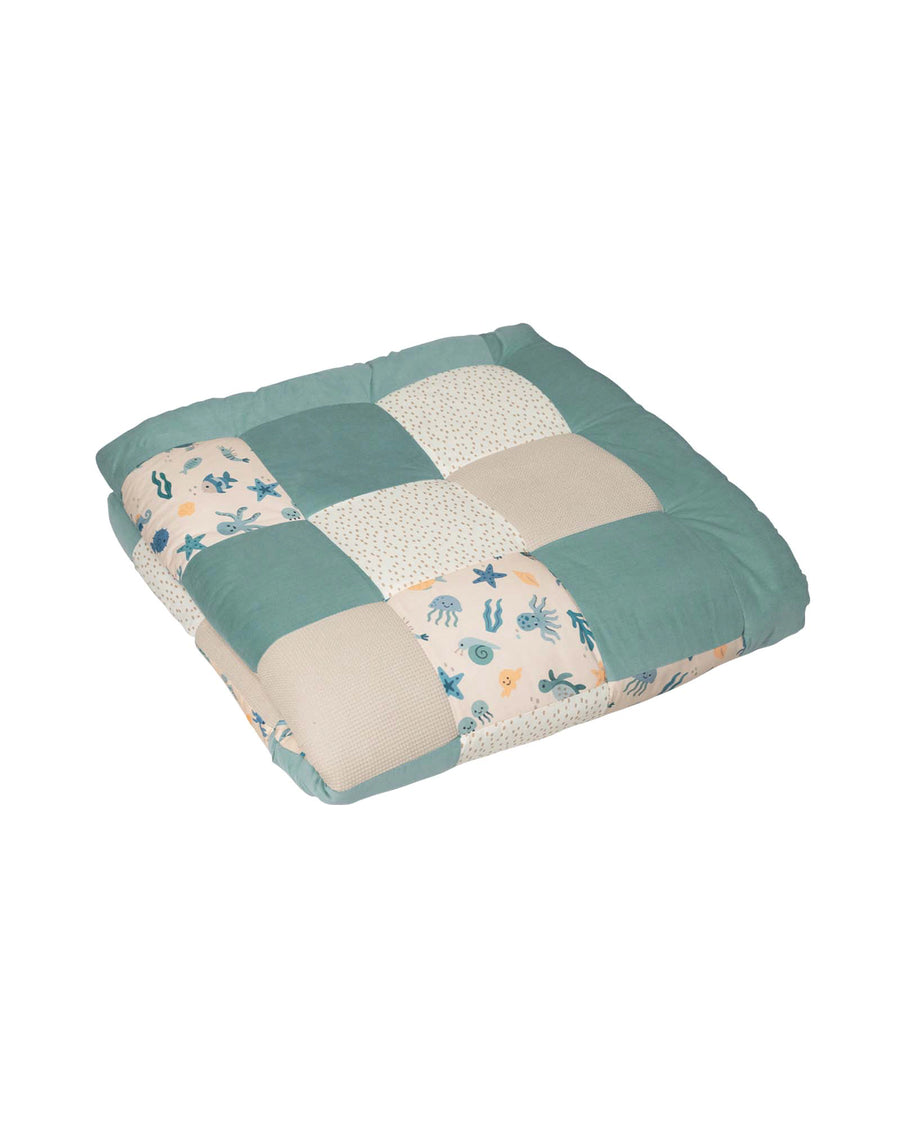 Soft, thick baby play mat with patchwork design in teal, beige, and white, featuring an underwater sea animal pattern.