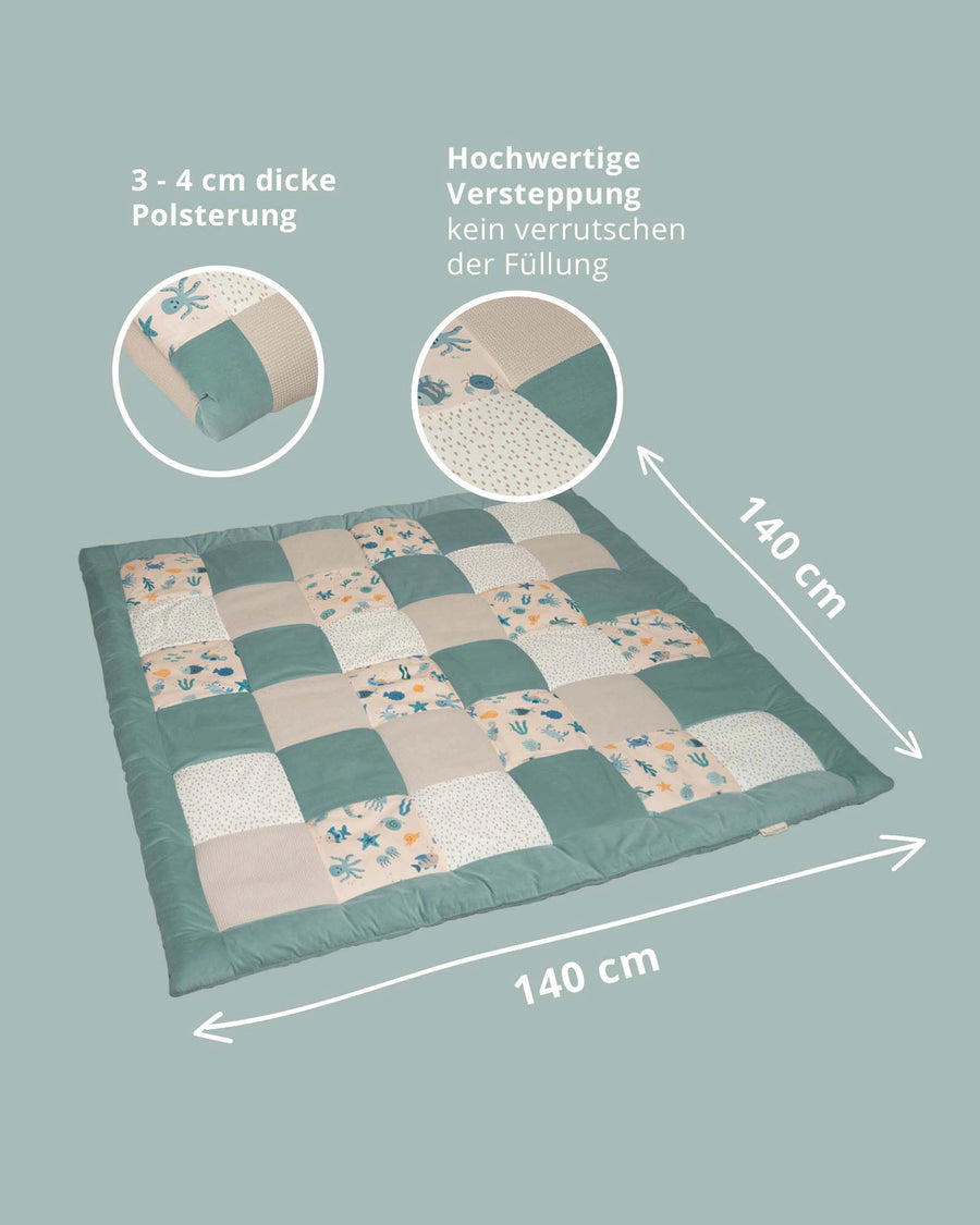 Square 140x140cm quilted baby play mat with underwater animal patchwork design in teal, beige, and white.