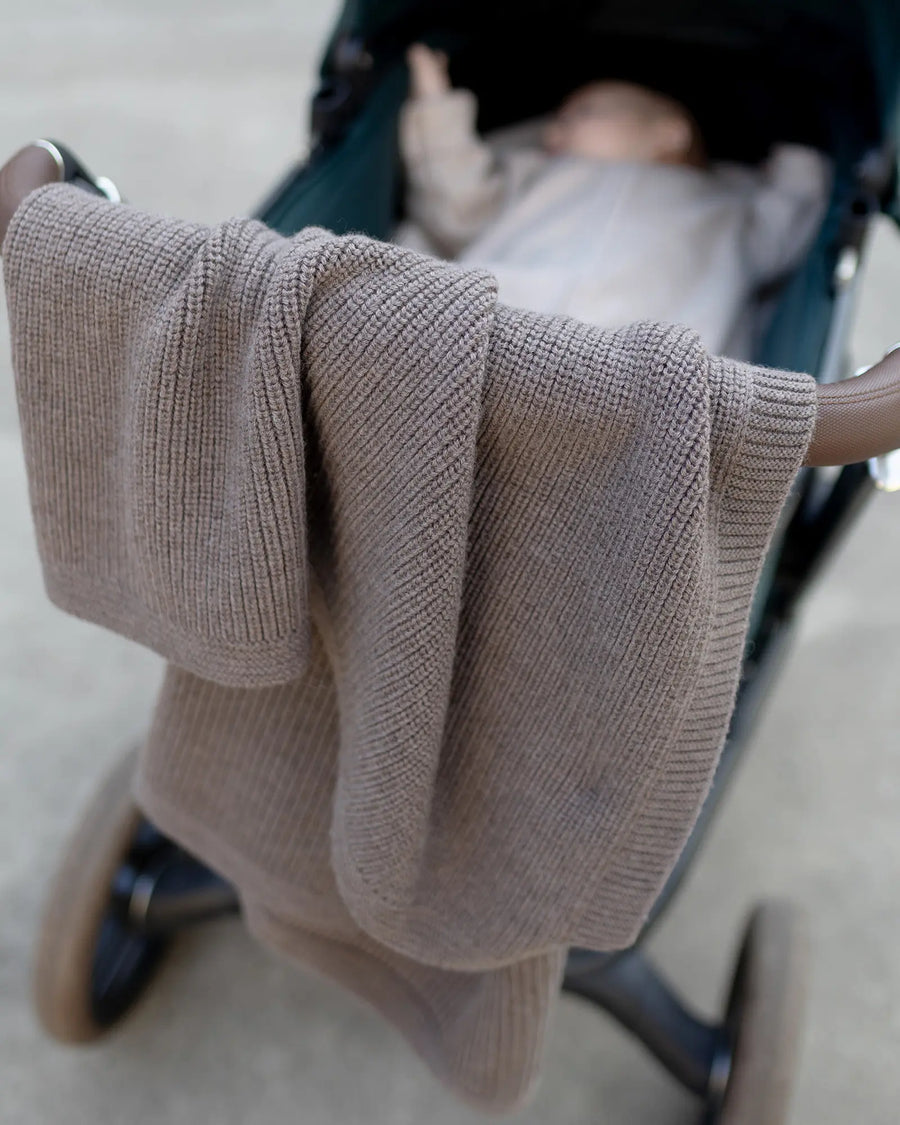 Babydecke Merinowolle Taupe über dem Kinderwagen mit Baby