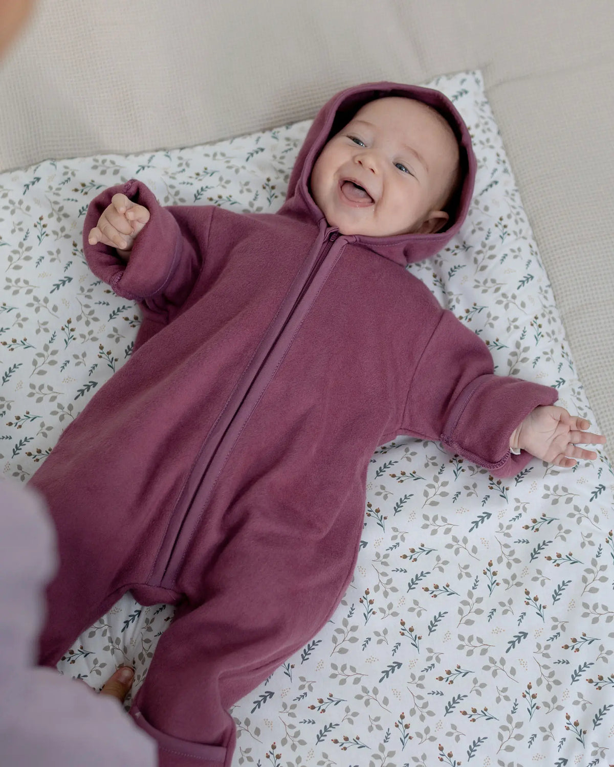 Baby im Baumwoll-Fleece Overall Beere Größe 74-80 auf der Decke