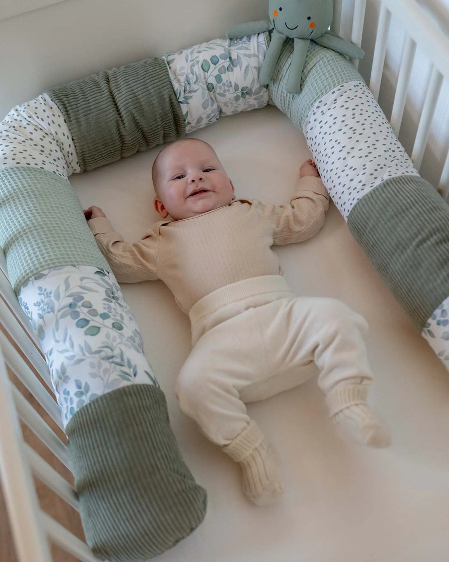 Bettschlange Blattliebe als Umrandung im Babybett