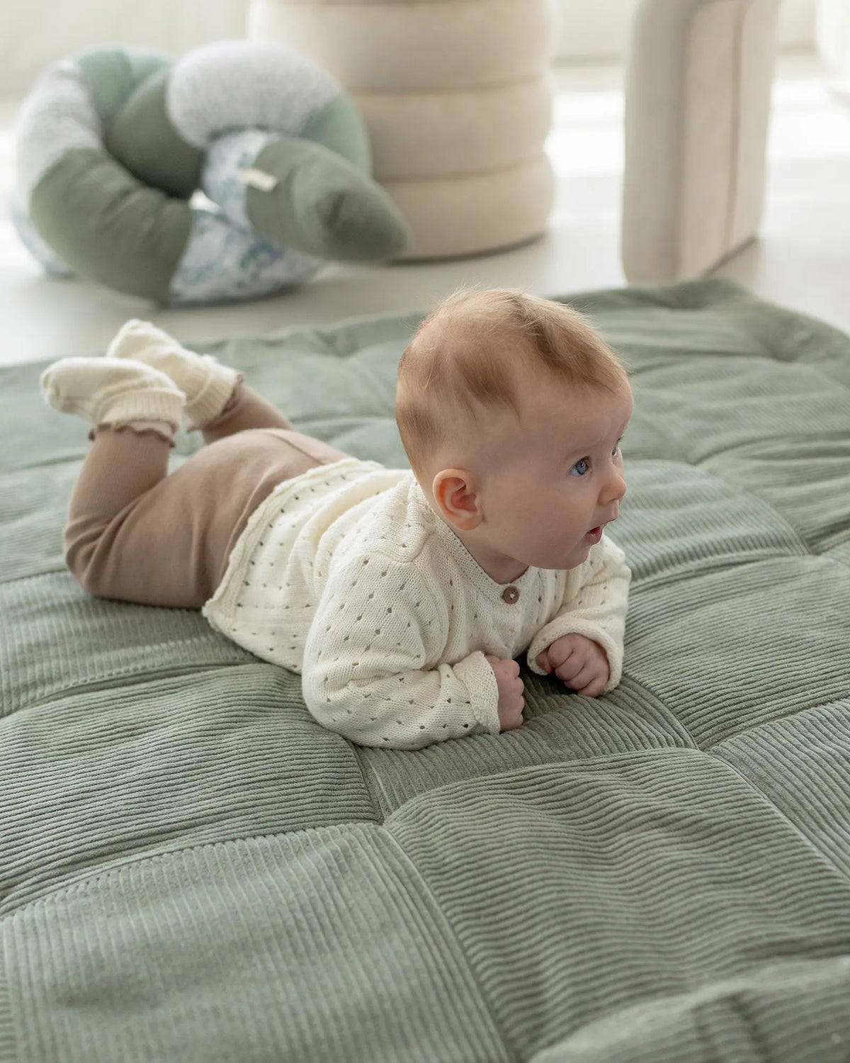Baby auf der Krabbeldecke Cord Salbeiwiese