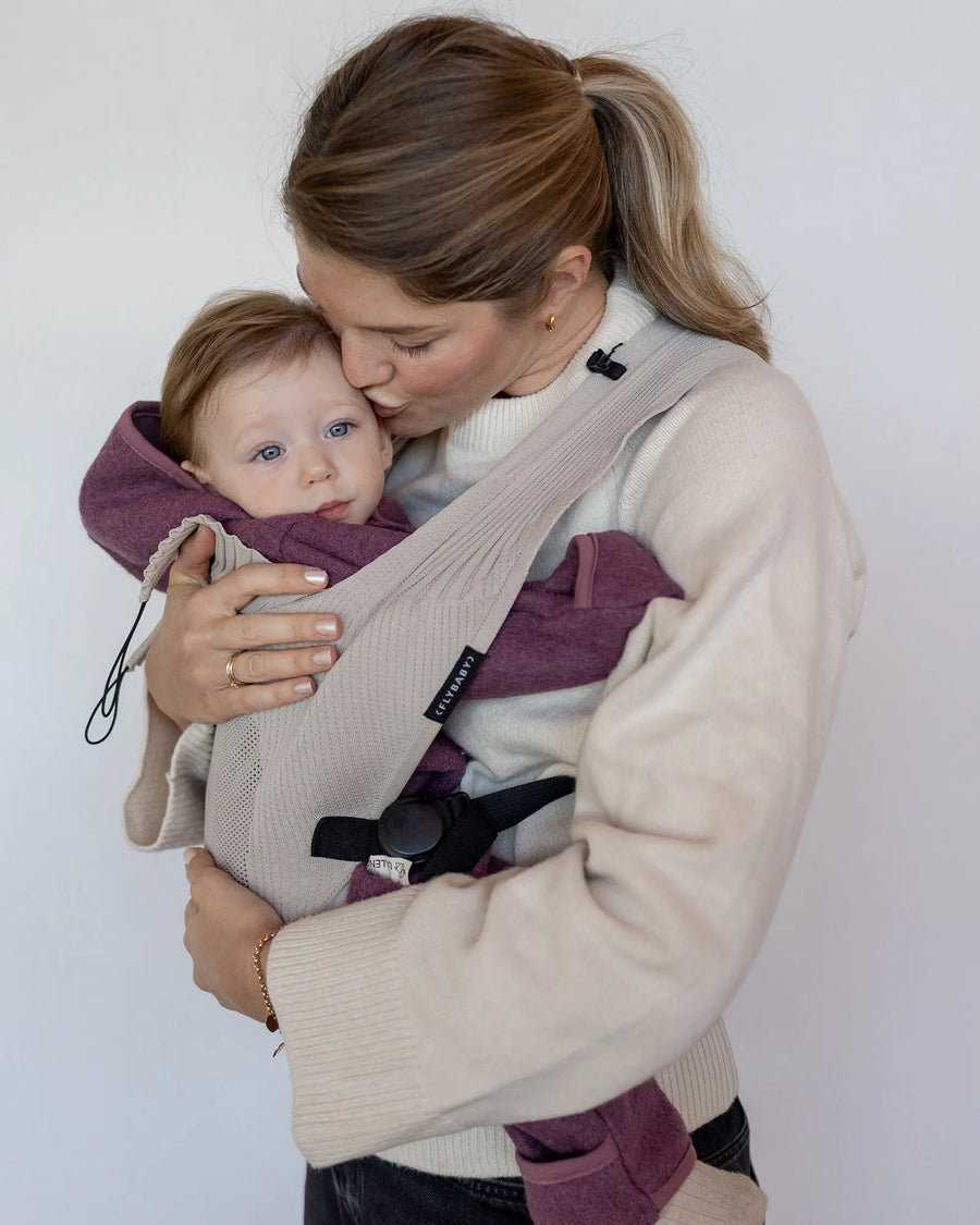 Baby im Wollwalk Overall Beere in der Babytrage