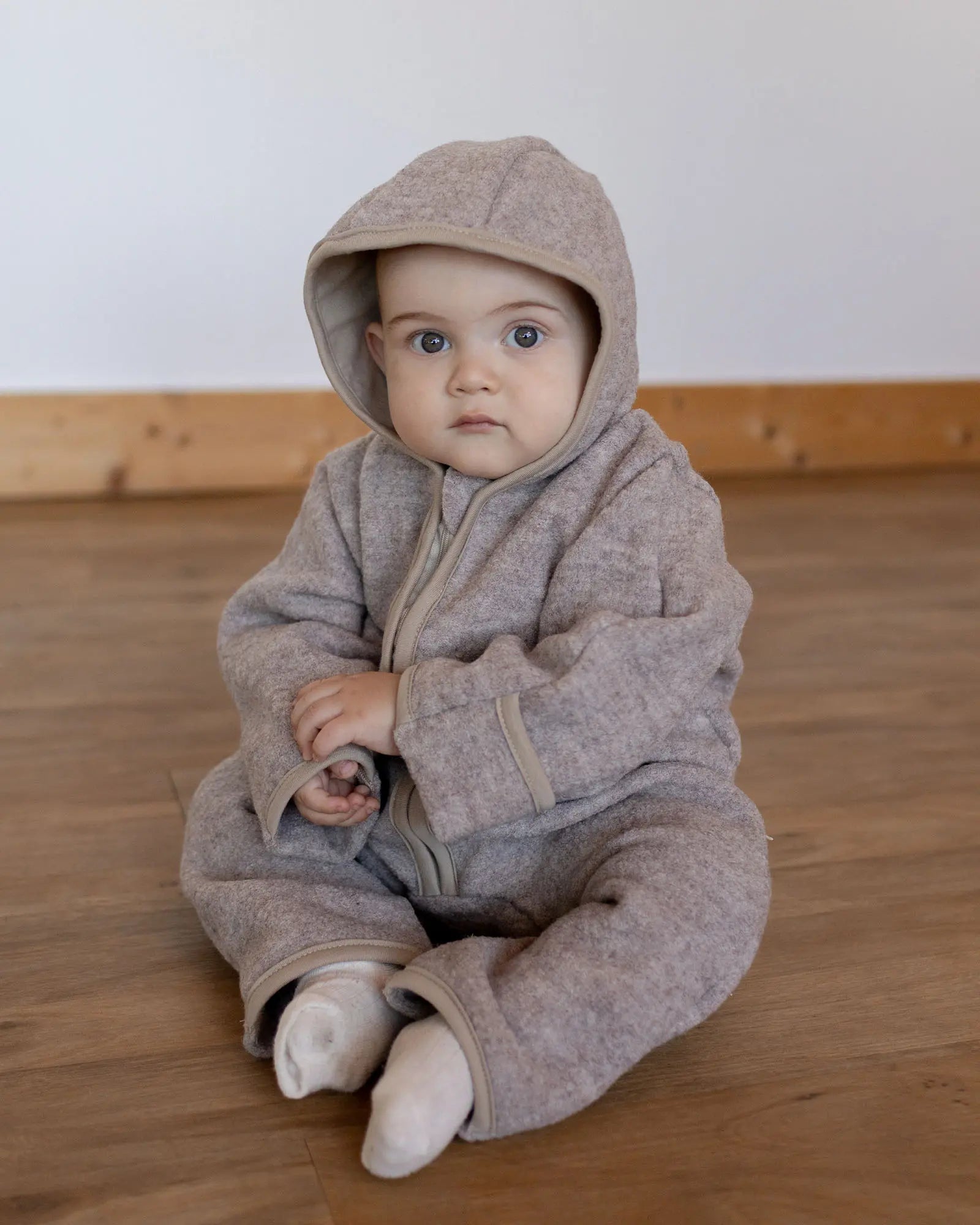 Kleinkind im Wollwalk Overall Hafer Beige beim Spielen