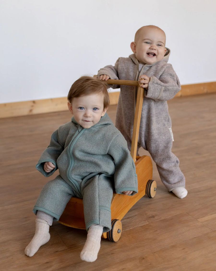 Baby im Wollwalk Overall Hafer Beige in der Babytrage